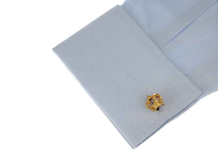 Gold crown cufflinks on a light blue dress shirt