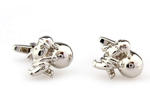 Silver astronaut cufflinks on a white background