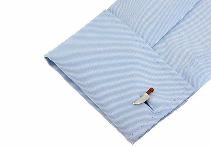 Light blue dress shirt cuff with a decorative button on a white background