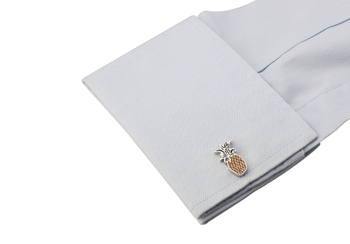 Cufflinks with pineapple design on a light gray shirt cuff