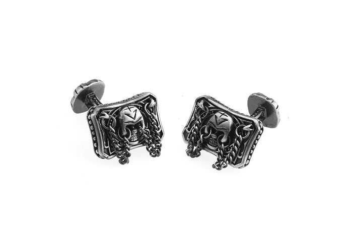 Pair of silver skull-themed cufflinks on a white background