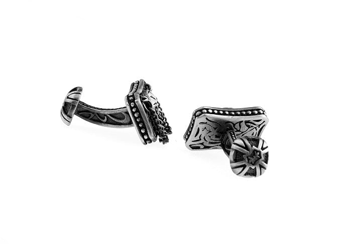 Pair of silver cufflinks with intricate designs on a white background