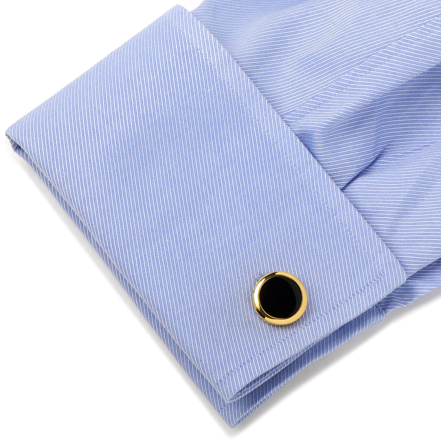 Folded light blue shirt with a cufflink on a white background
