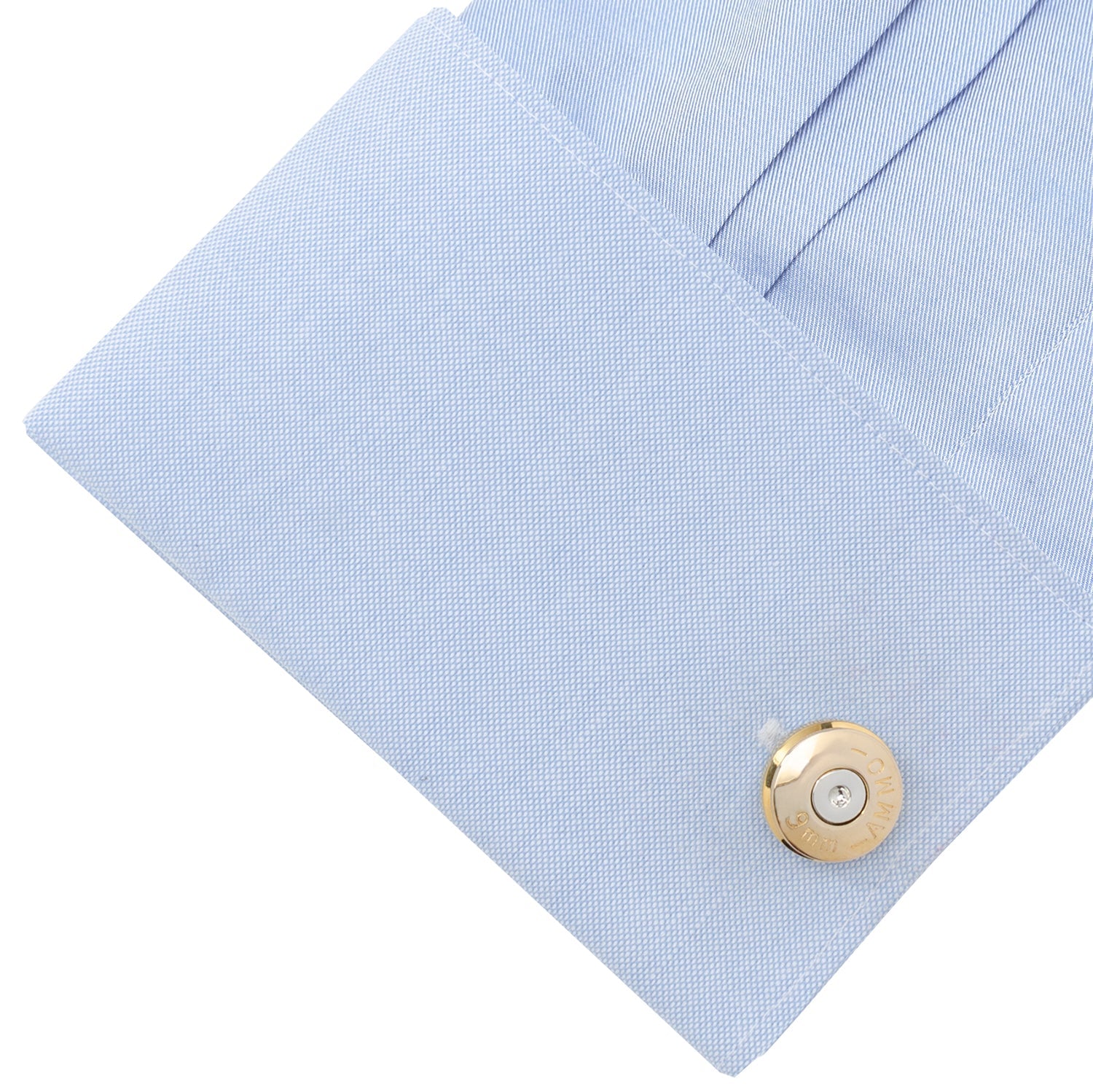 Close-up of a light blue shirt with a gold button on a white background