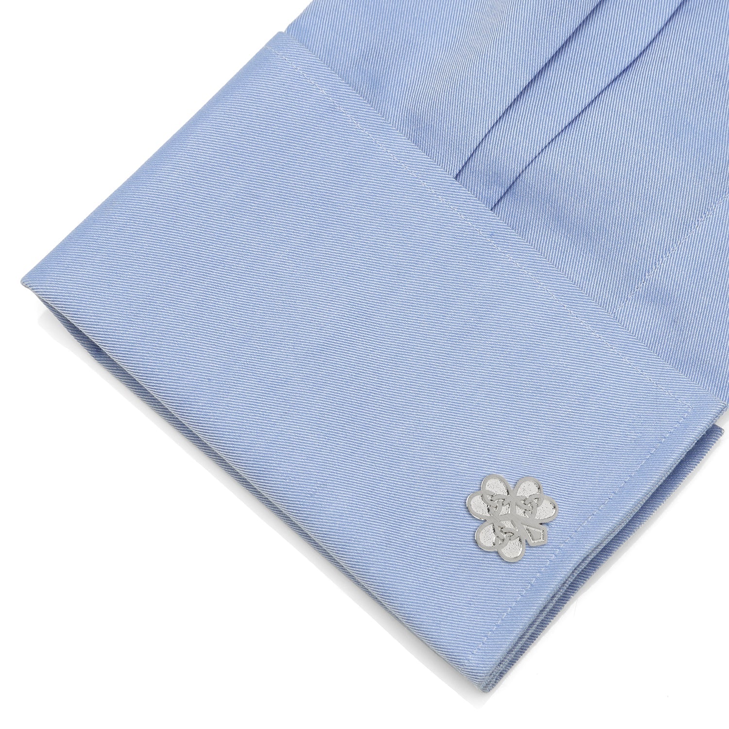 Light blue dress shirt with a silver flower-shaped cufflink on a white background