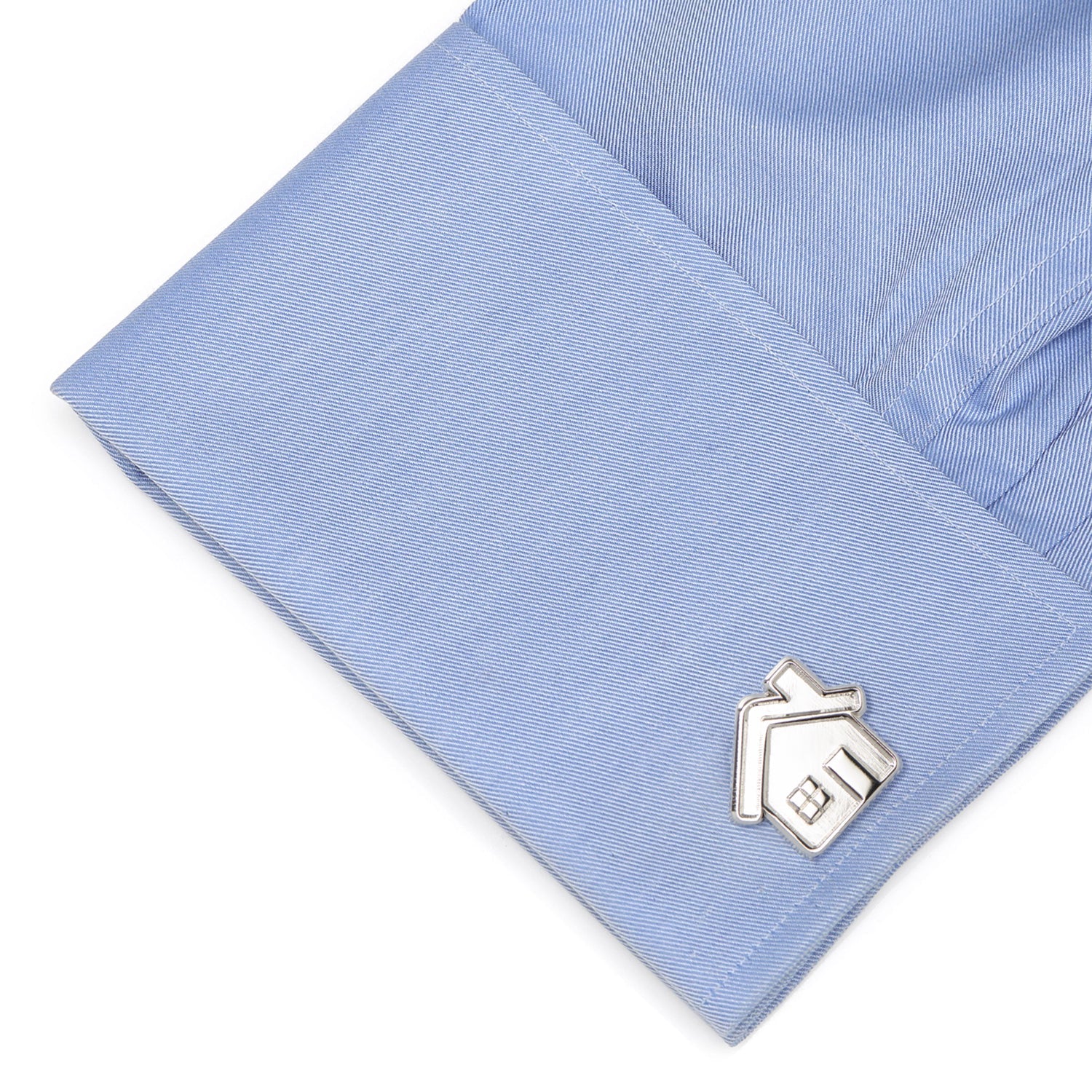 Silver house-shaped cufflink on a light blue shirt