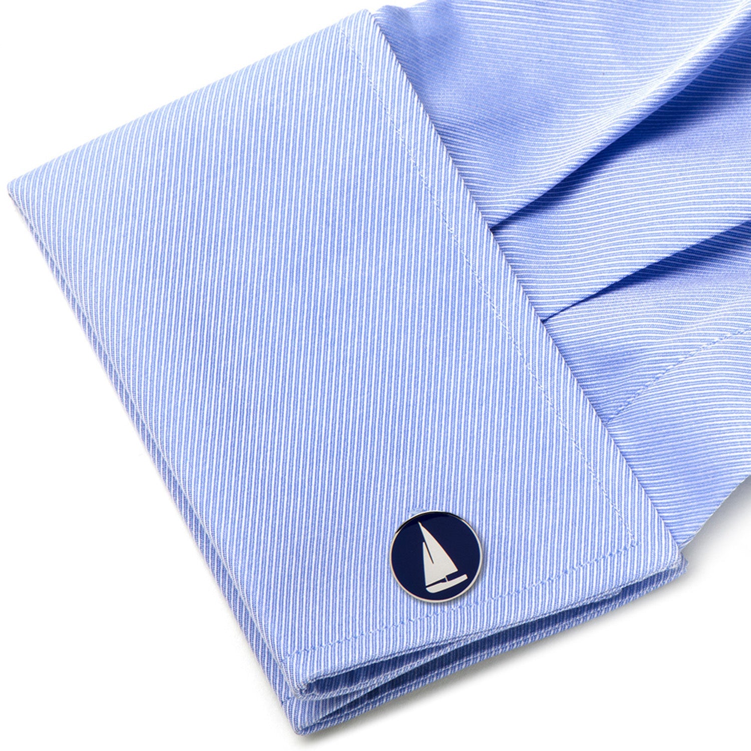 Folded light blue shirt with a sailboat emblem on a white background