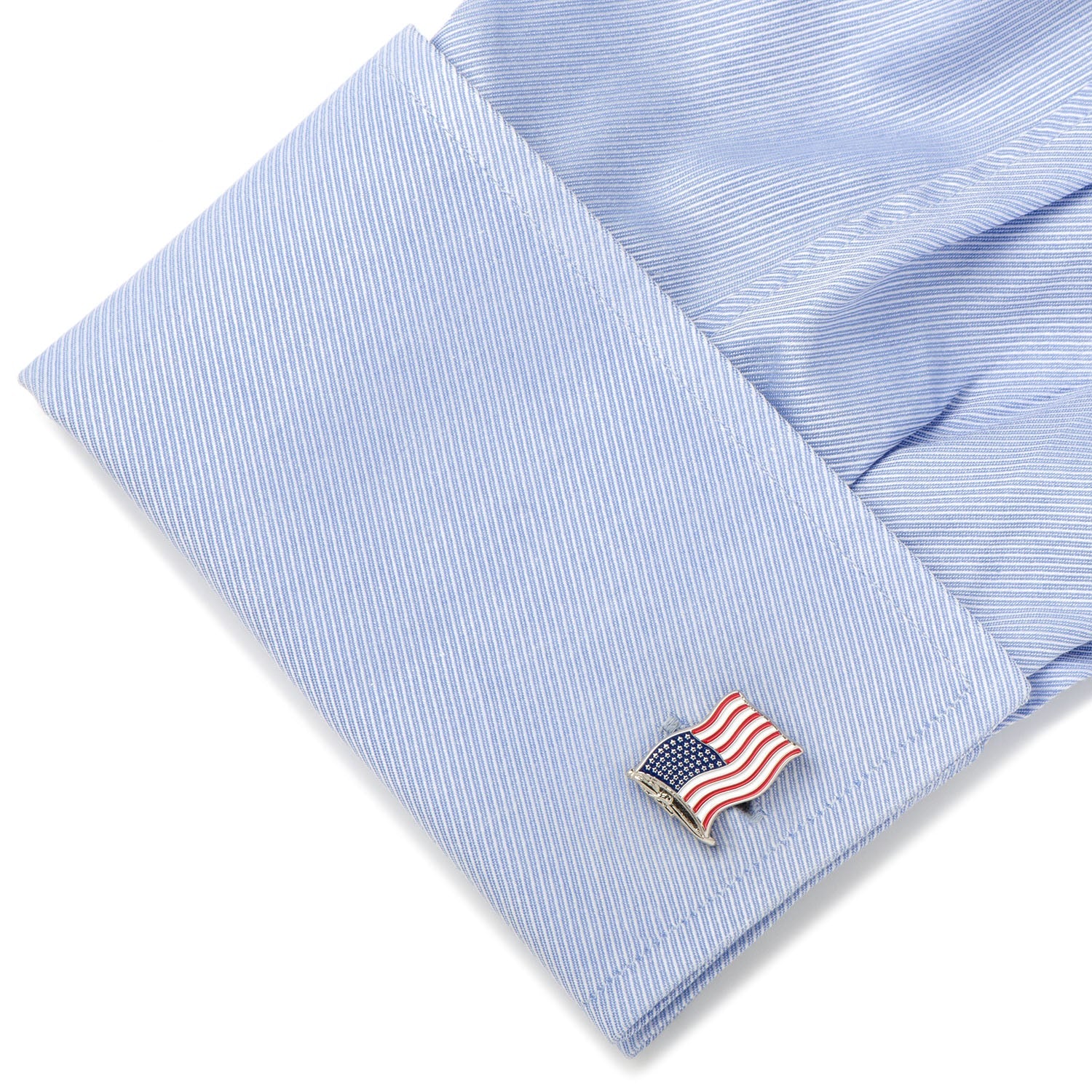 Blue striped shirt cuff with American flag cufflink on a white background