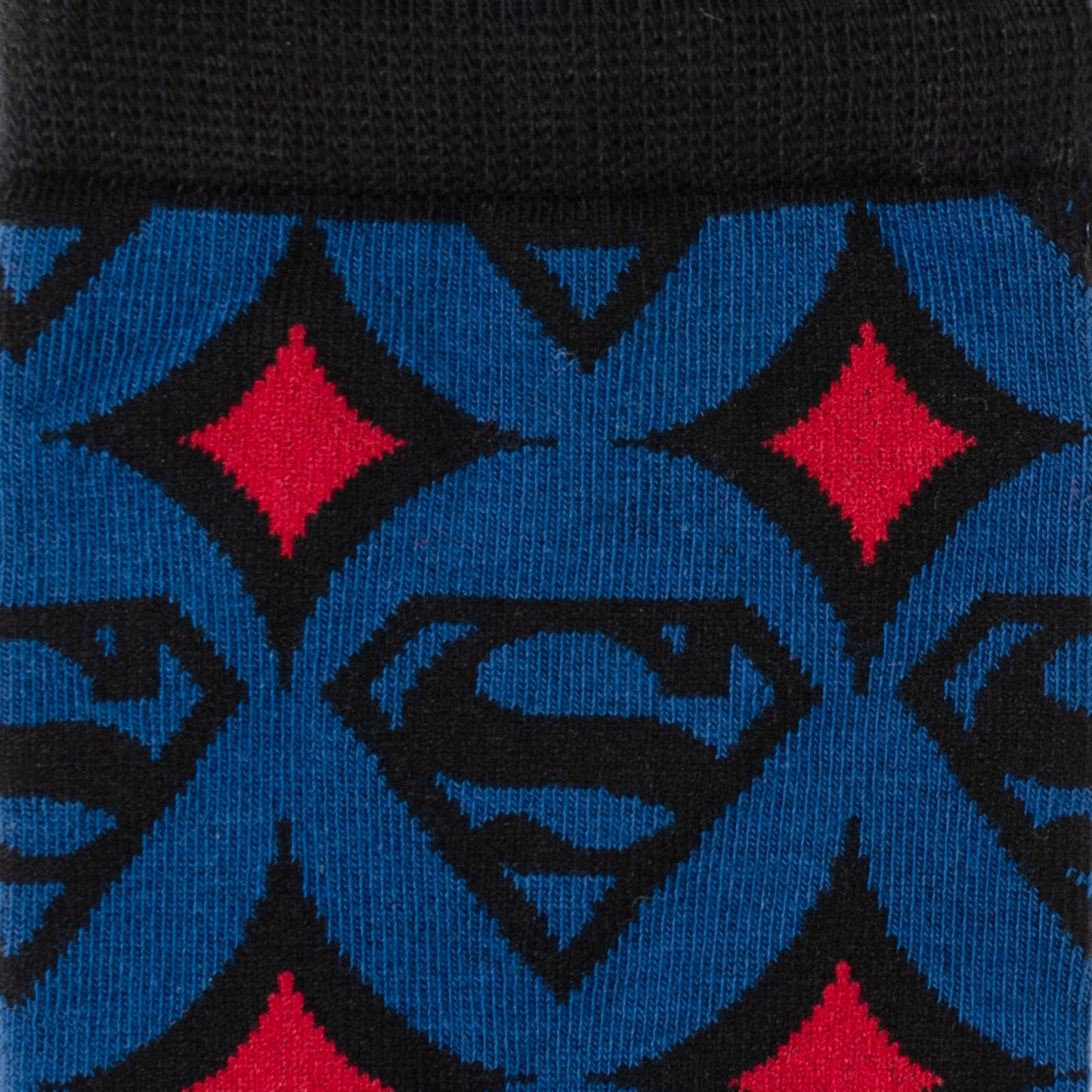 Close-up of Superman logo with red diamonds on blue background