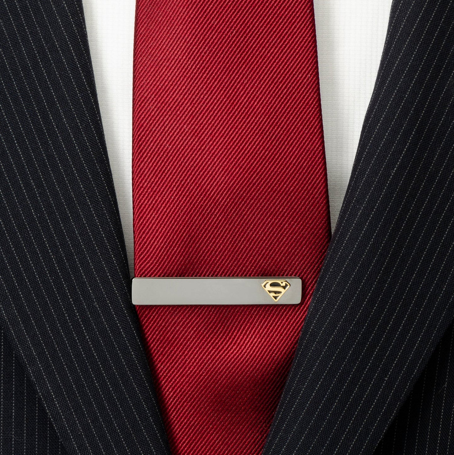 Red tie with a Superman logo tie clip on a suit background