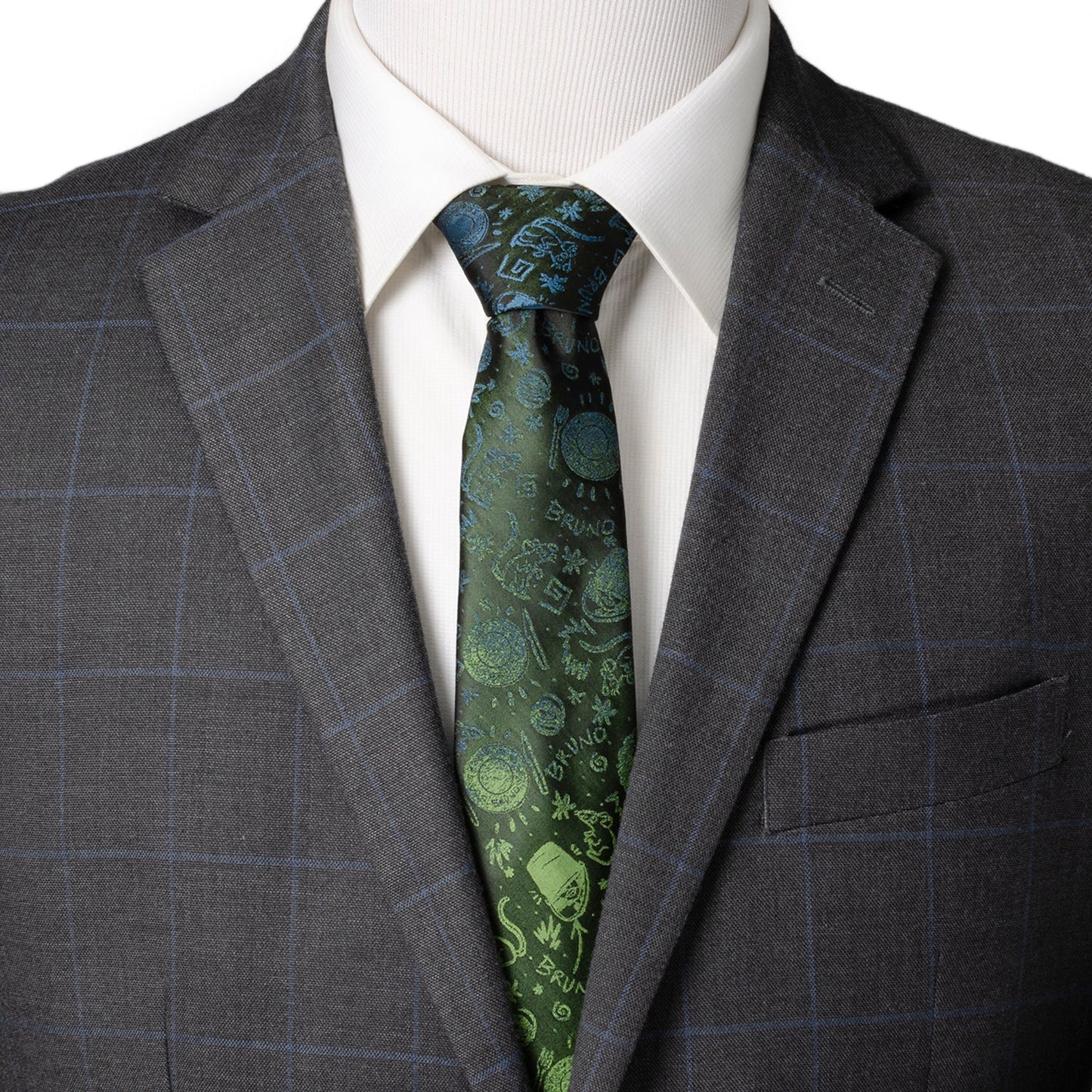 Gray suit jacket with a white shirt and green patterned tie on a mannequin. Encanto Bruno