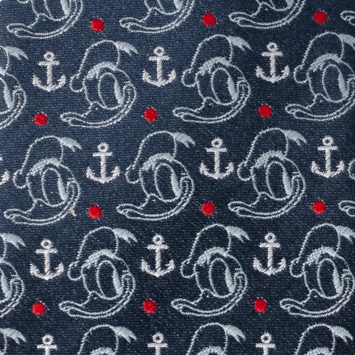 Navy blue fabric with white anchors, red dots, and gray shapes. Donald Duck