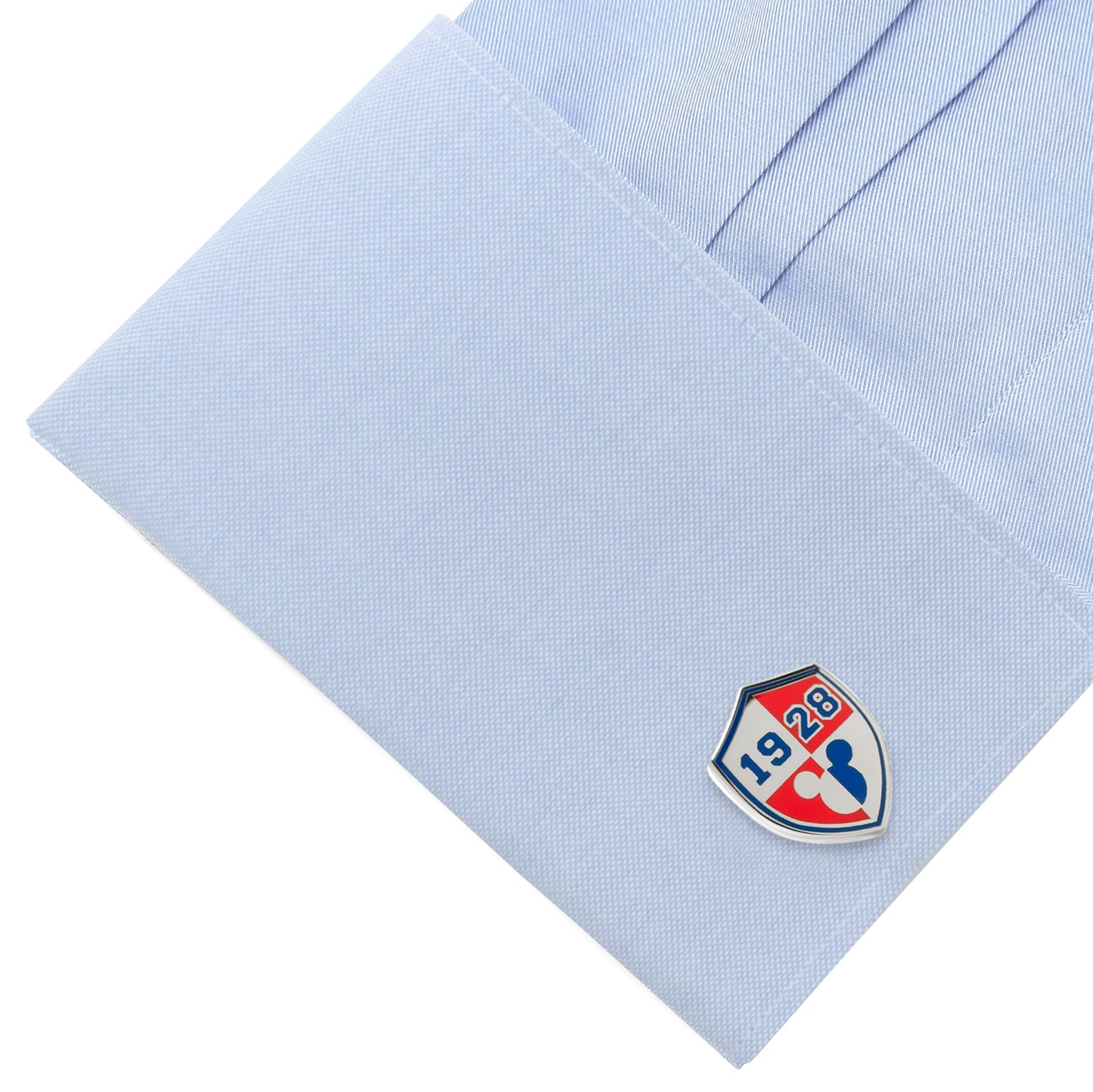 Cufflink with a logo on a light blue shirt