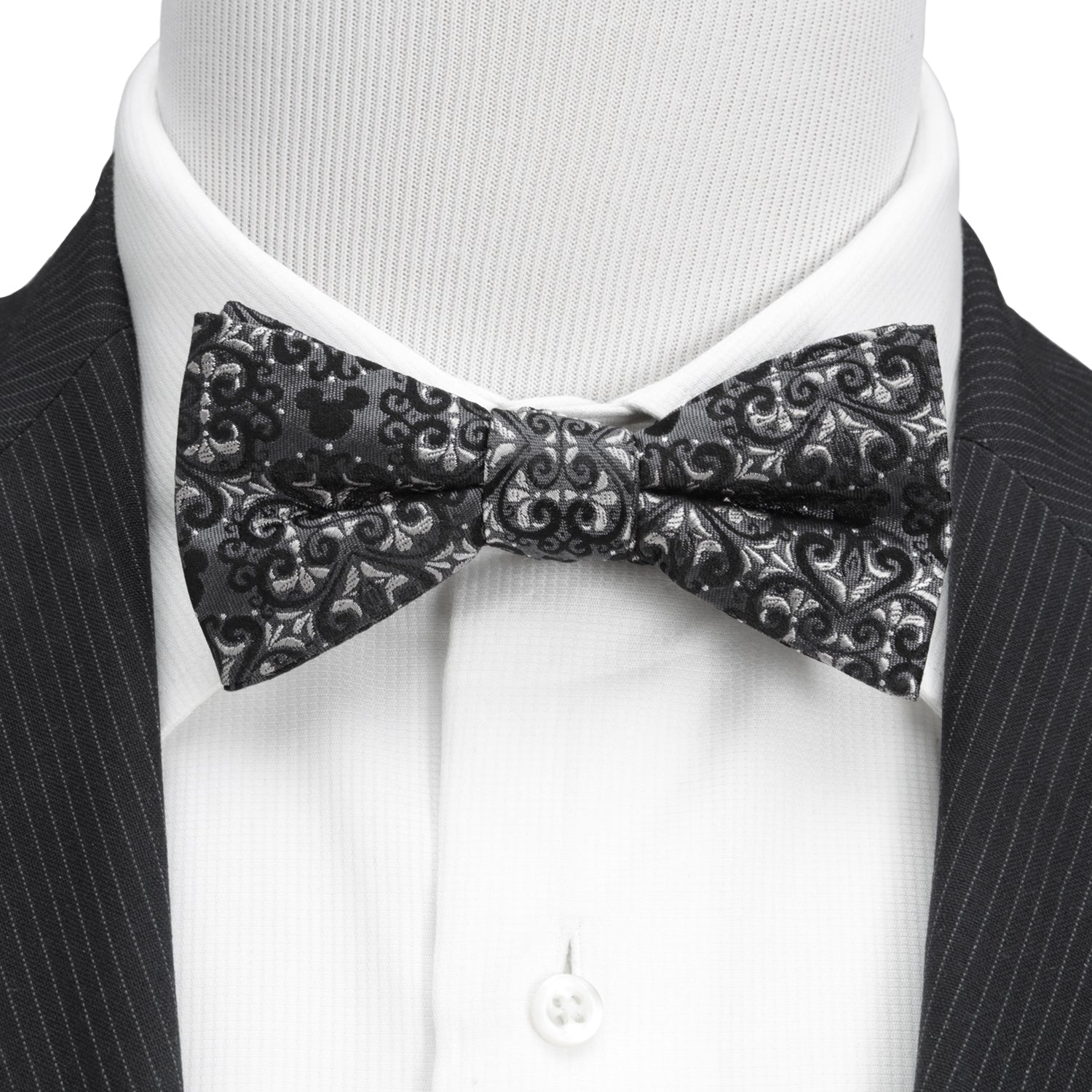 Black patterned bow tie on a mannequin with a black suit and white shirt. Mickey Mouse