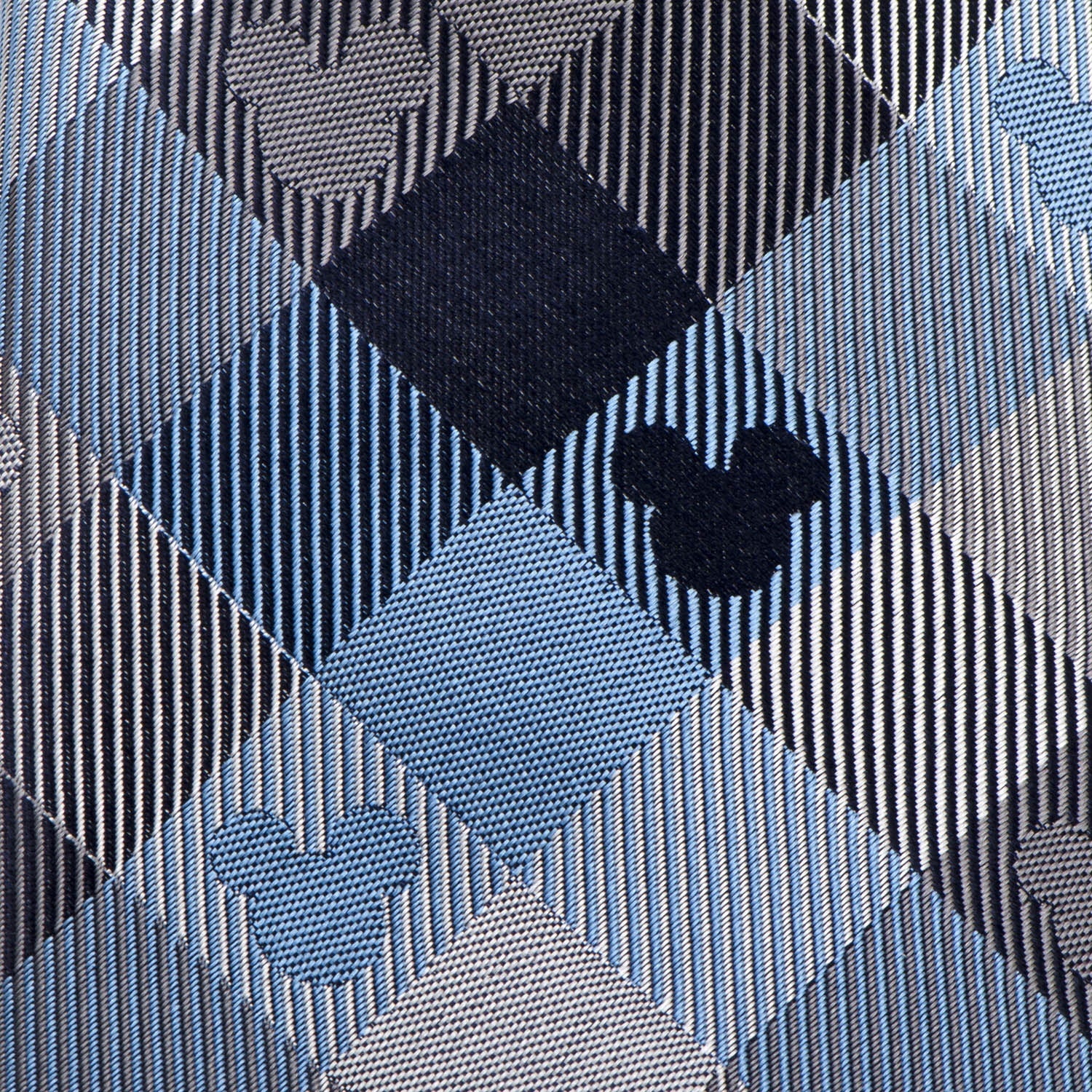 Close-up of a patterned tie with geometric shapes in blue, black, and gray.
