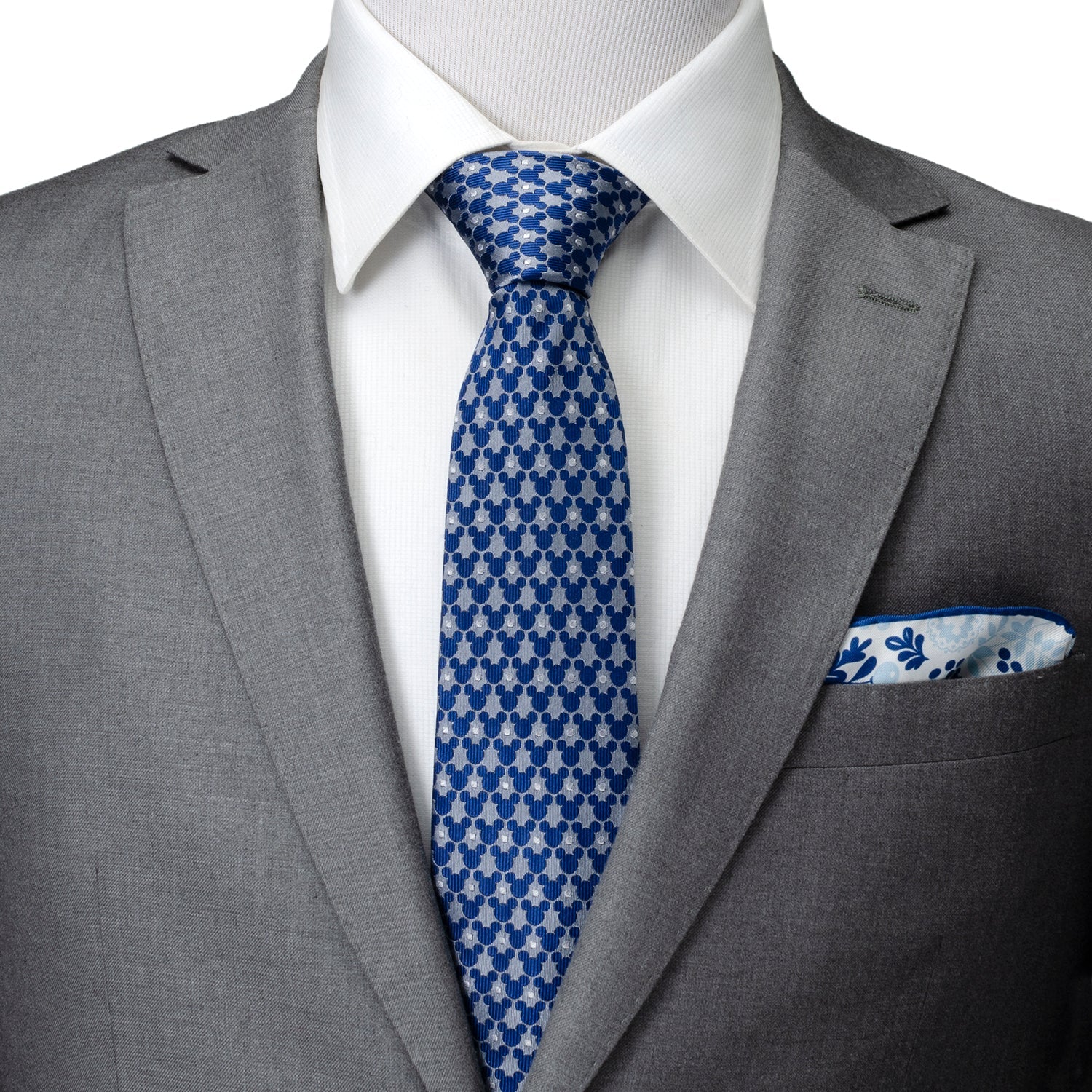 Gray suit with a blue patterned tie and matching pocket square on a white background