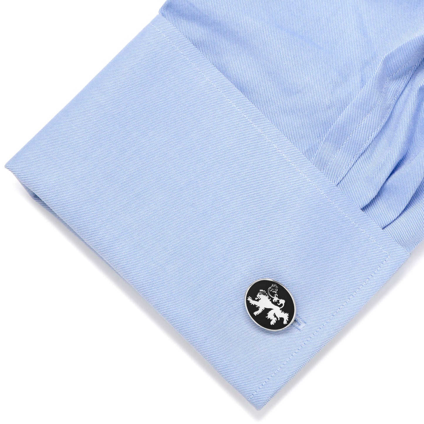 Cufflink on a light blue shirt with a white background