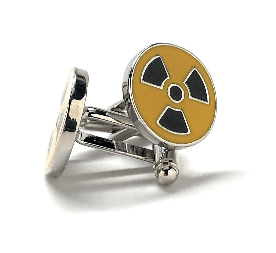 A pair of yellow and black enamel cufflinks with a radioactive symbol design.