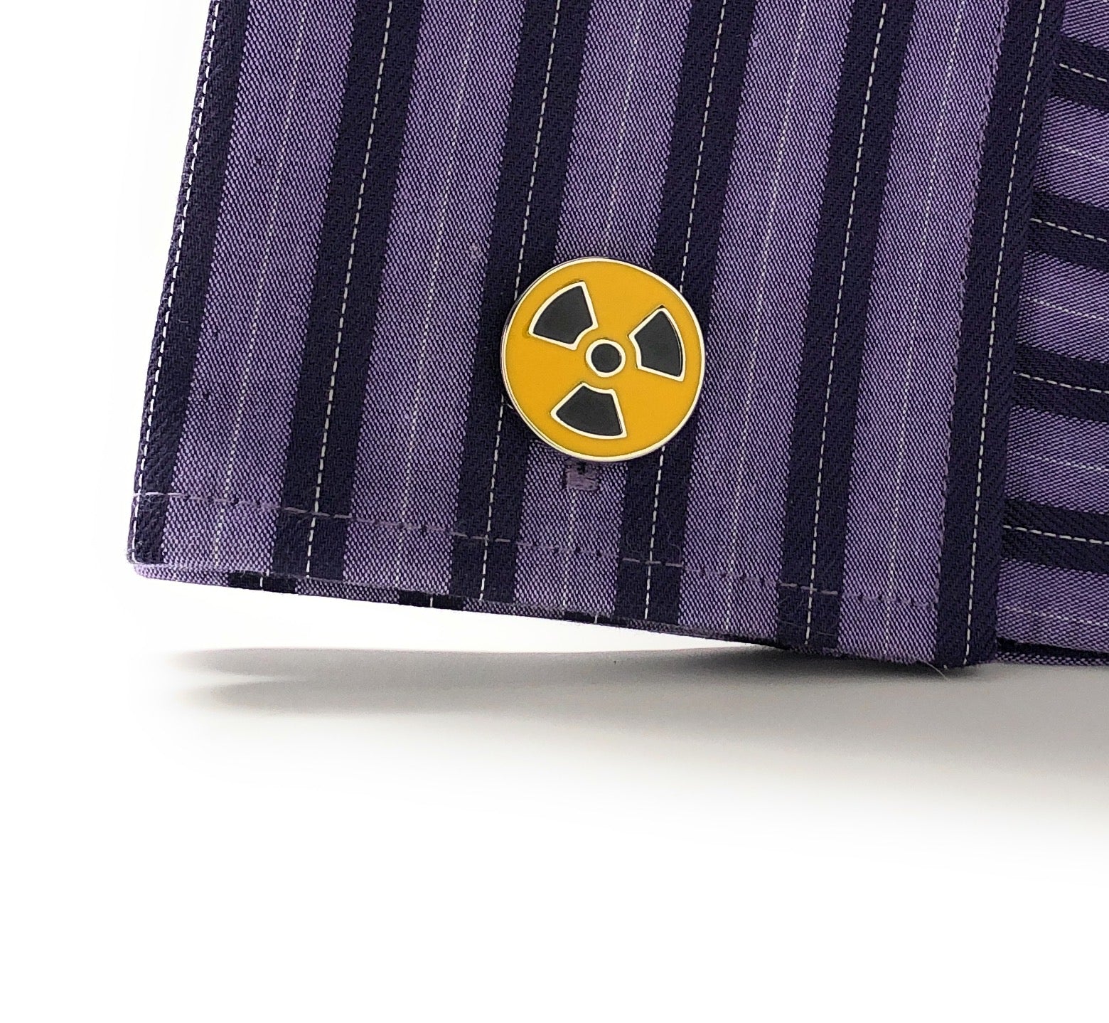 A pair of yellow and black enamel cufflinks with a radioactive symbol design. Purple Shirt