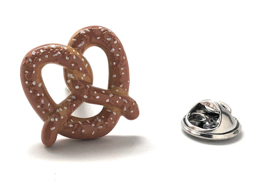 An enamel pin in the shape of a pretzel with a silver rhodium plating and brown white enamel details, including a butterfly backing.