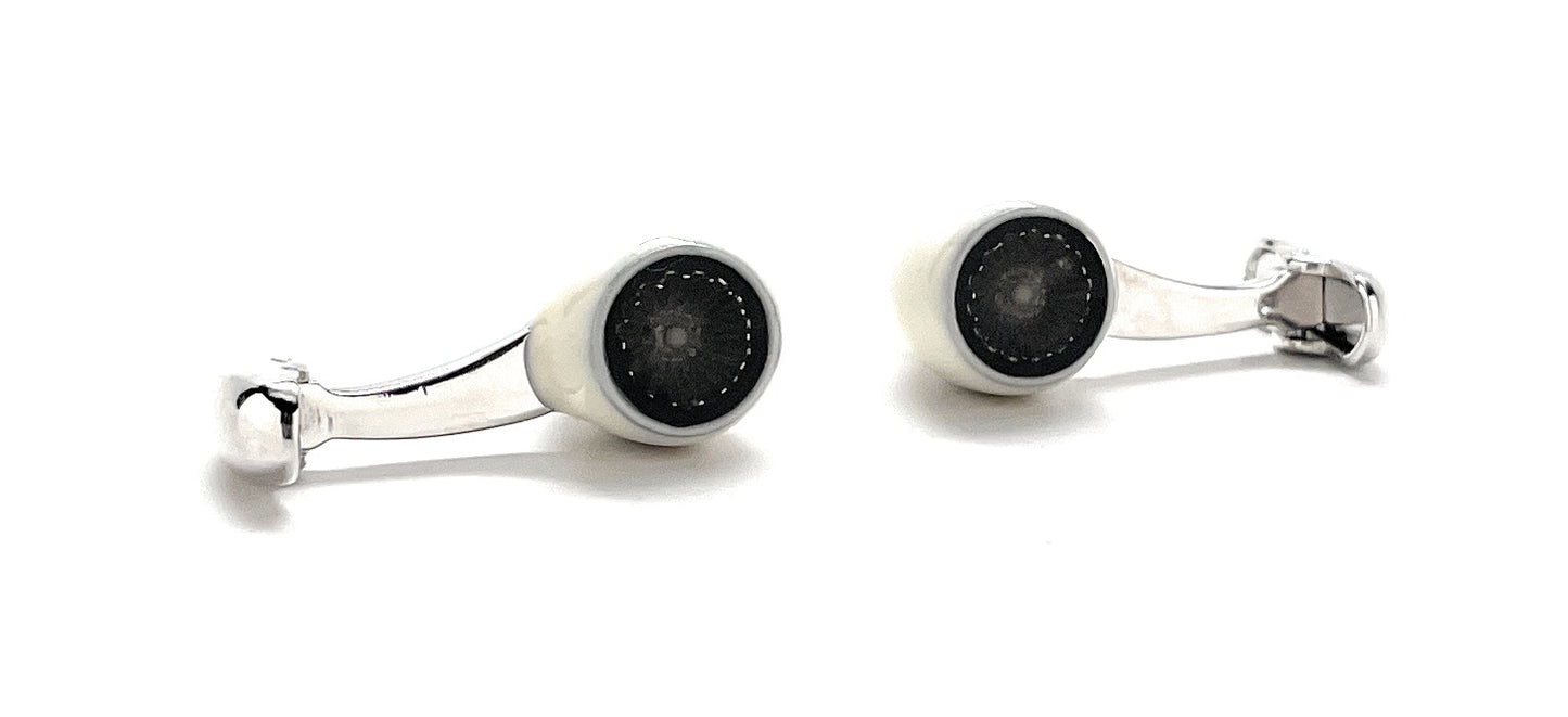 Pair of cufflinks with black circular centers and silver accents on a white background