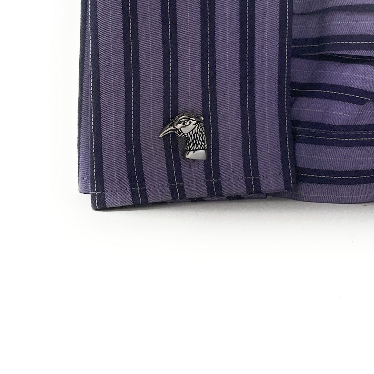 Close-up of a purple striped shirt with a decorative button on a white background
