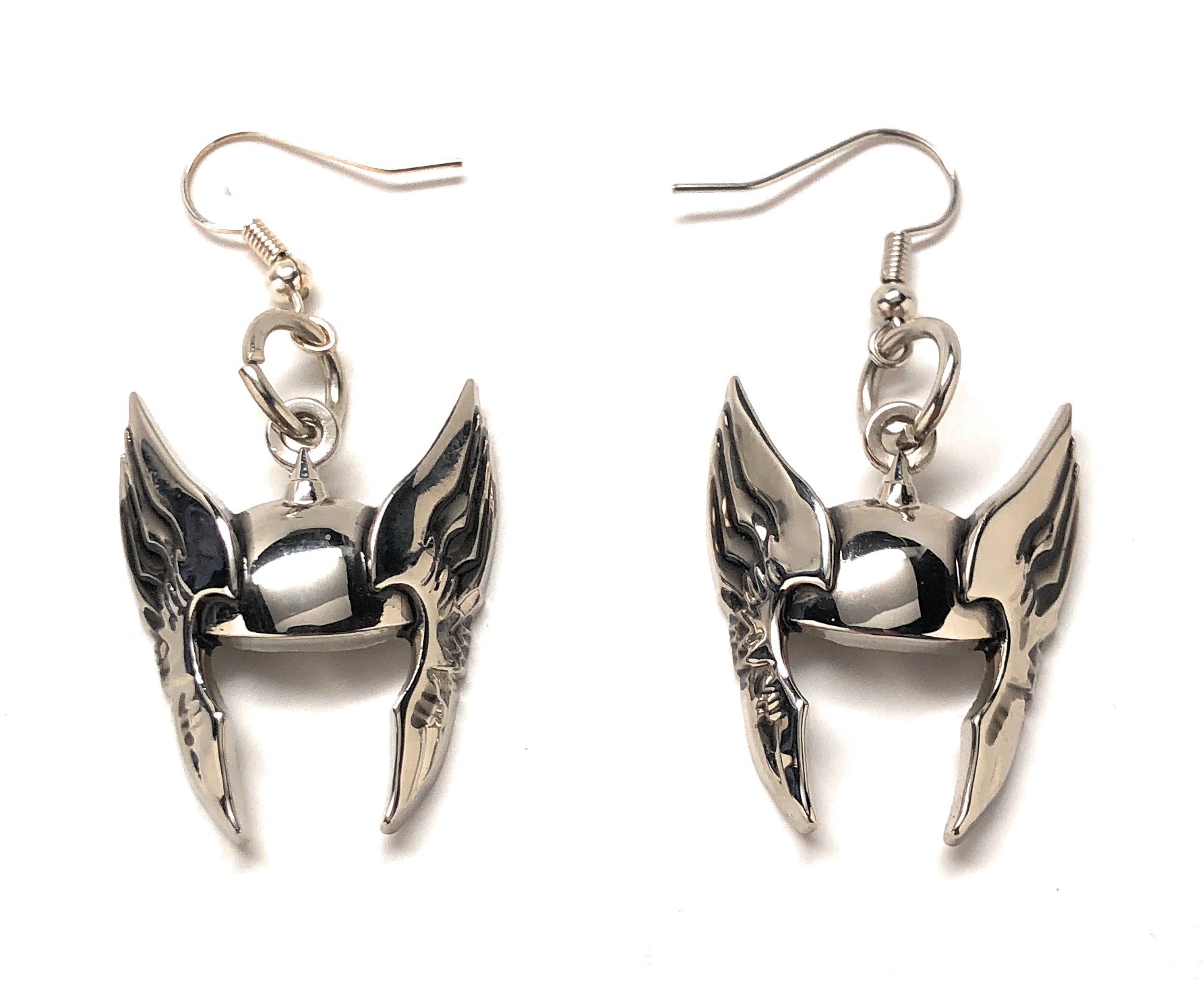 Pair of silver wing-shaped earrings on a white background