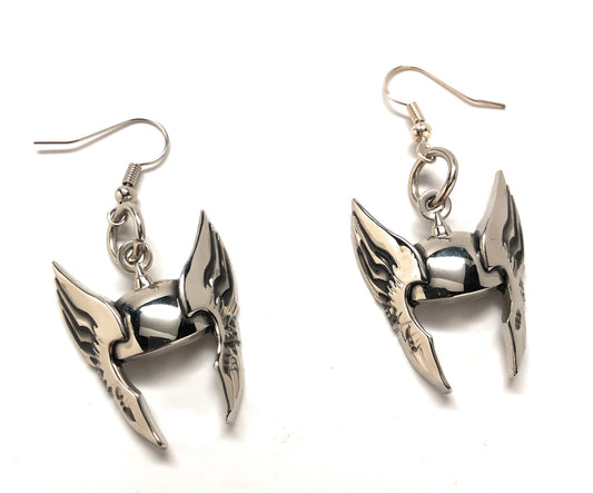 Pair of silver wing-shaped earrings on a white background