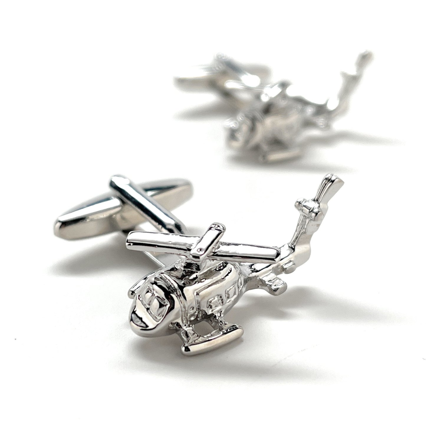 Silver helicopter-shaped cufflinks on a white background