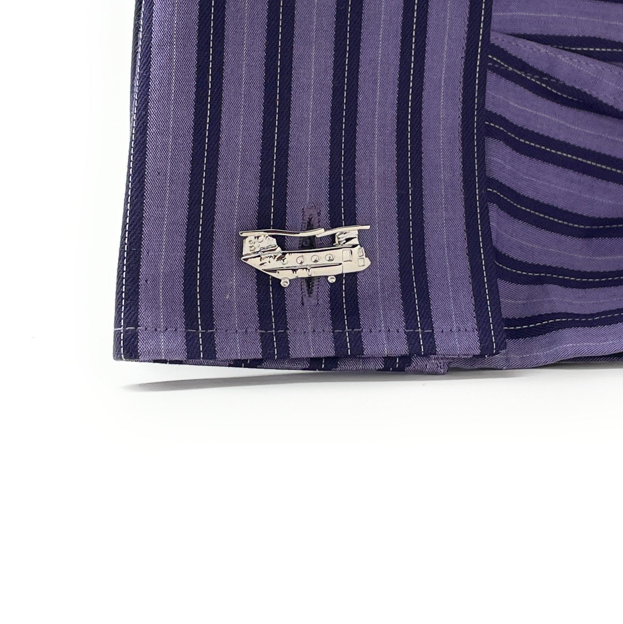 Close-up of a purple striped shirt with a decorative pin on a white background