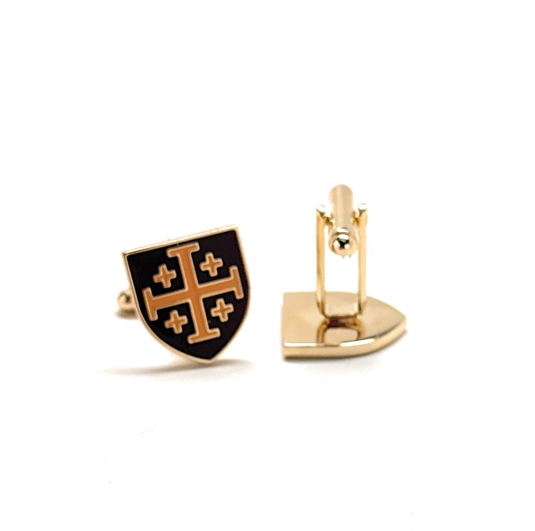 Gold and black cufflinks with a shield design on a white background