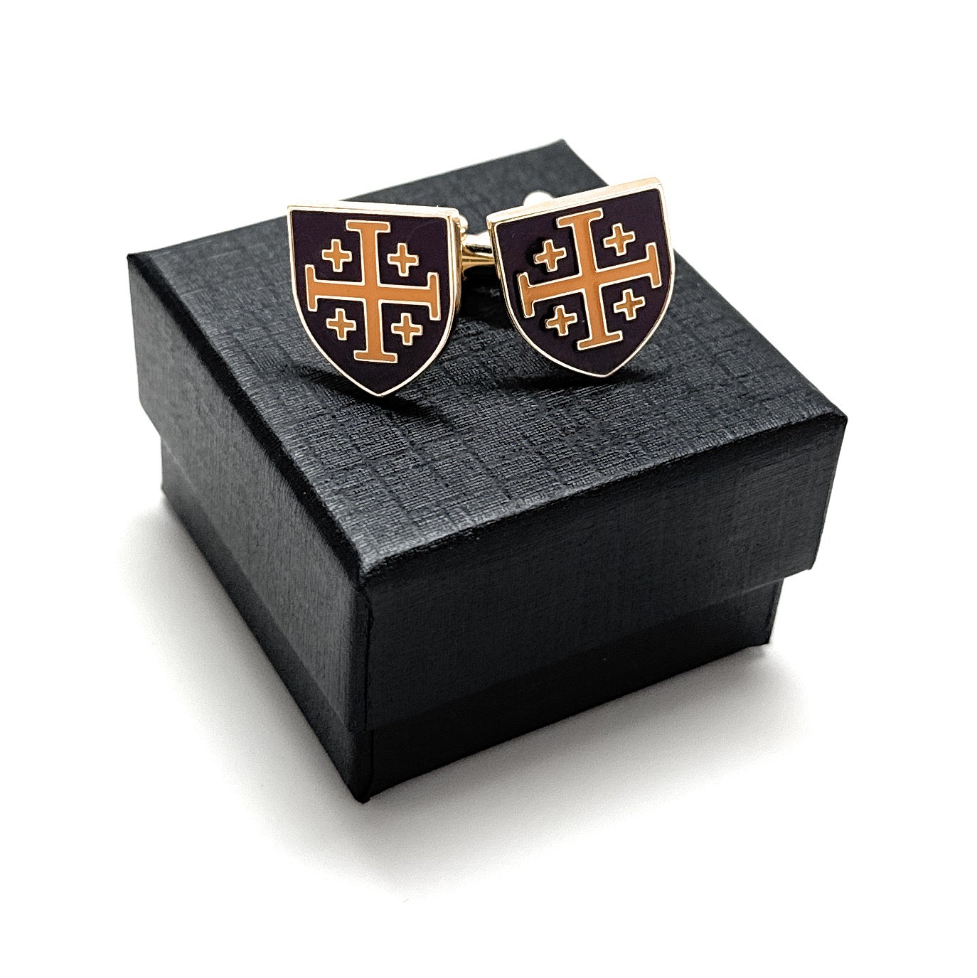 Cufflinks with a shield design featuring crosses on a black box