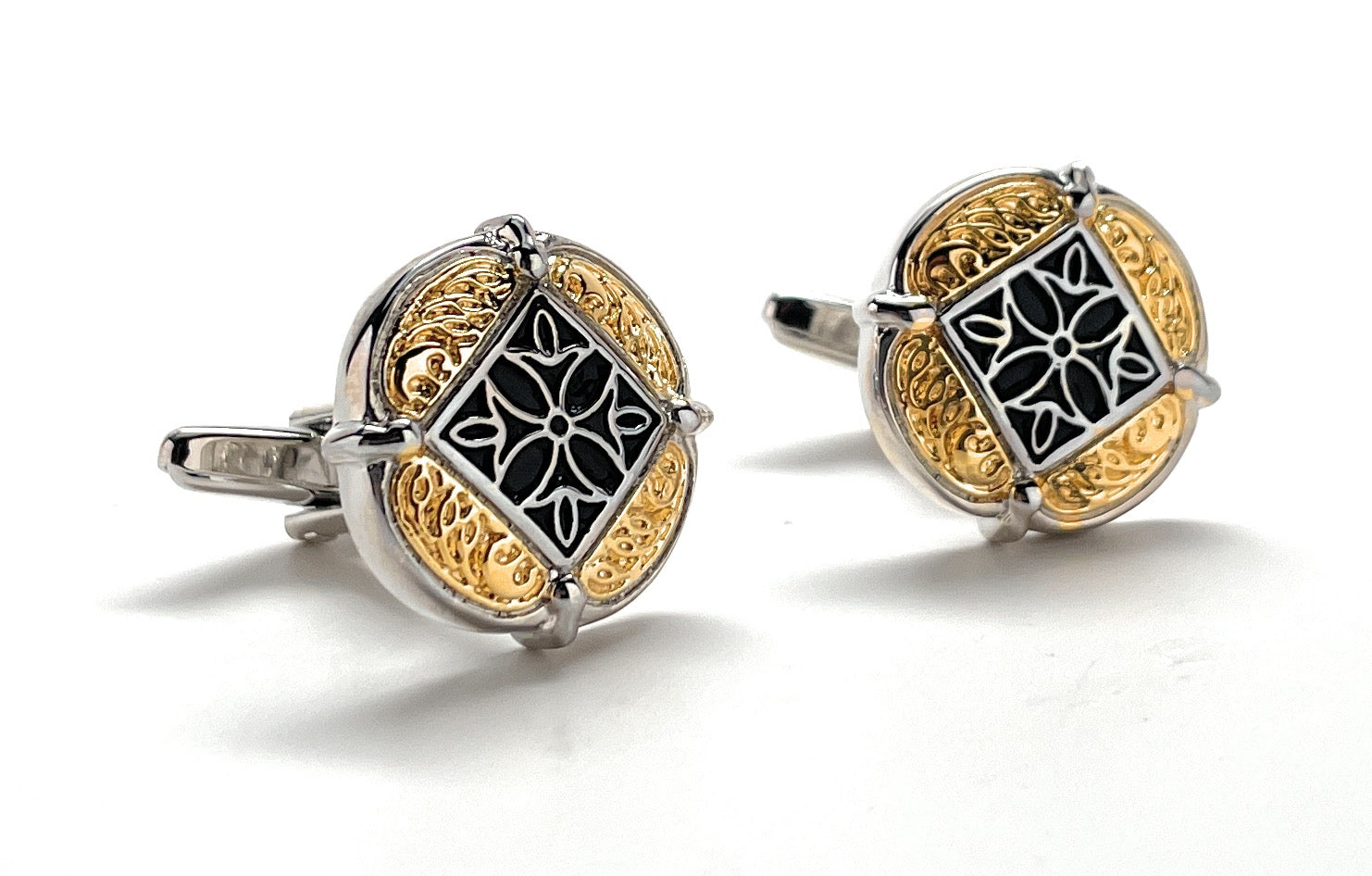 Gold and silver cufflinks with intricate design on a white background