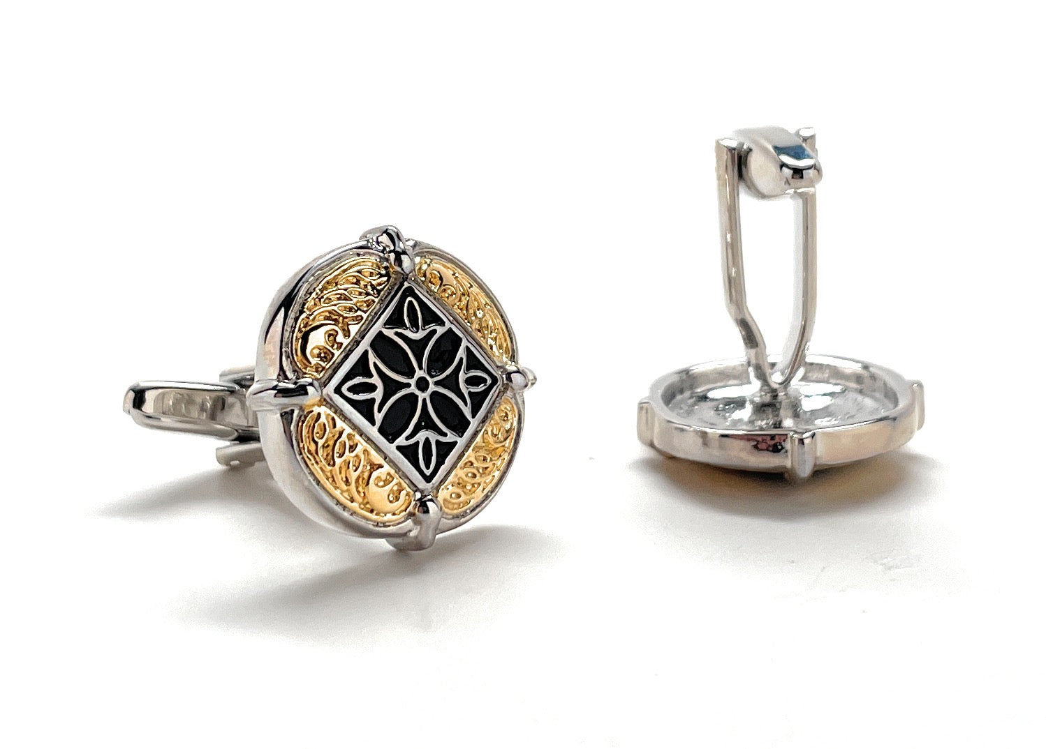 Silver and gold cufflinks with intricate design on a white background