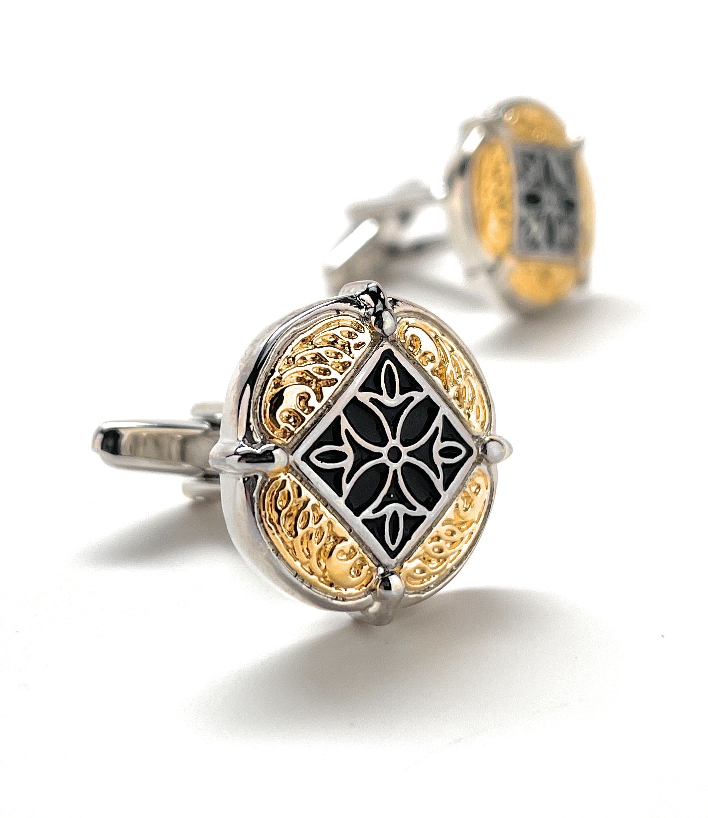 Decorative cufflinks with intricate design on a white background