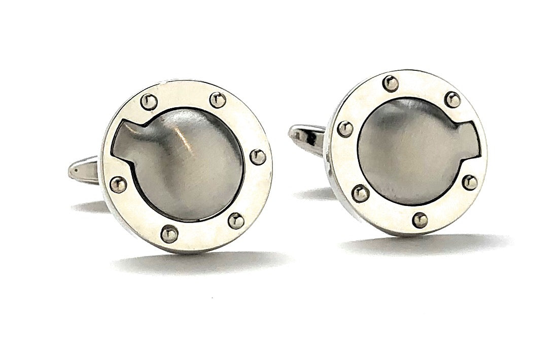 Pair of silver cufflinks with circular design on a white background