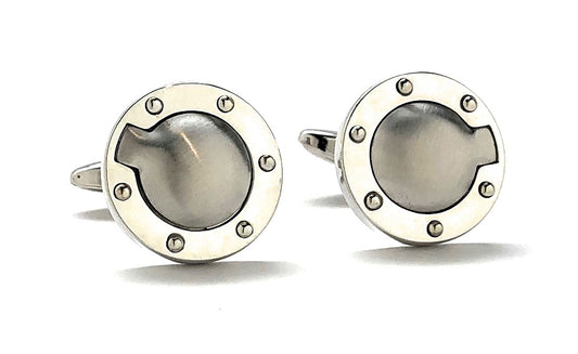 Pair of silver cufflinks with circular design on a white background