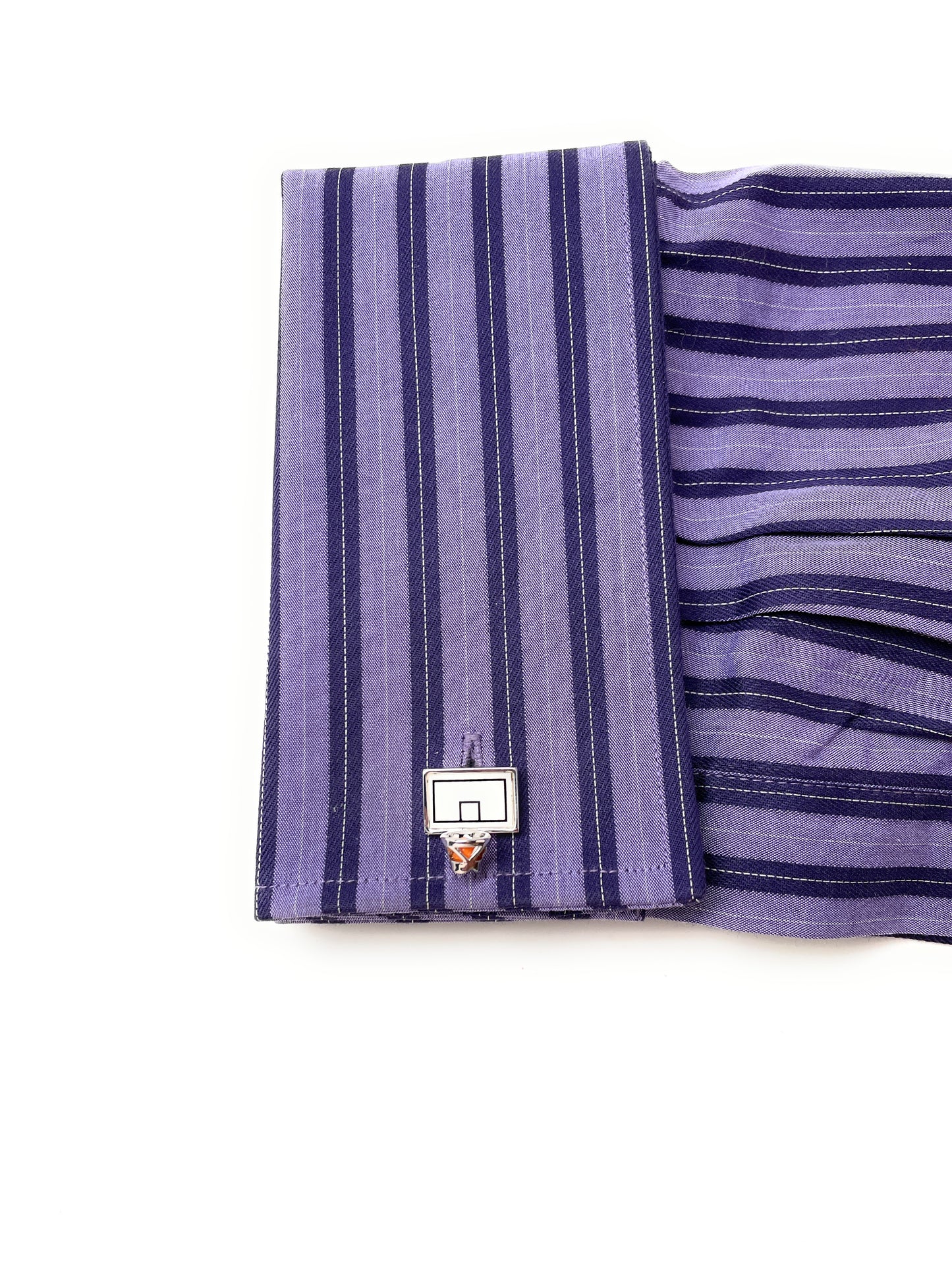 Purple striped fabric with a small basketball hoop pin on a white background