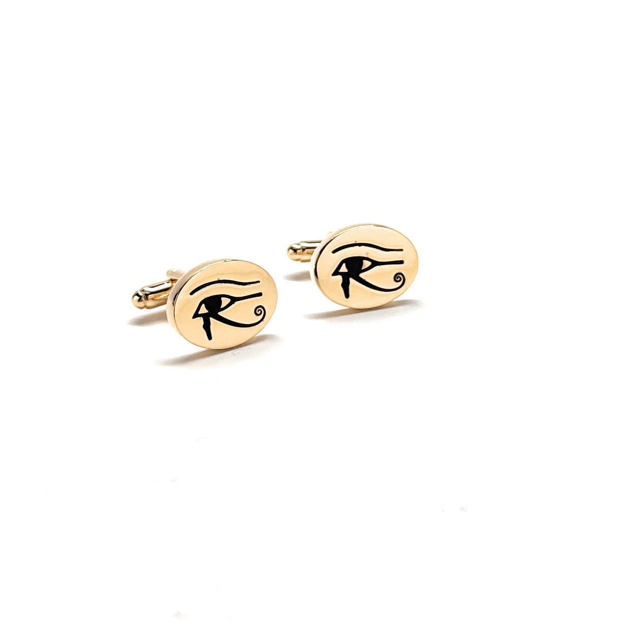 Gold cufflinks with eye design on a white background