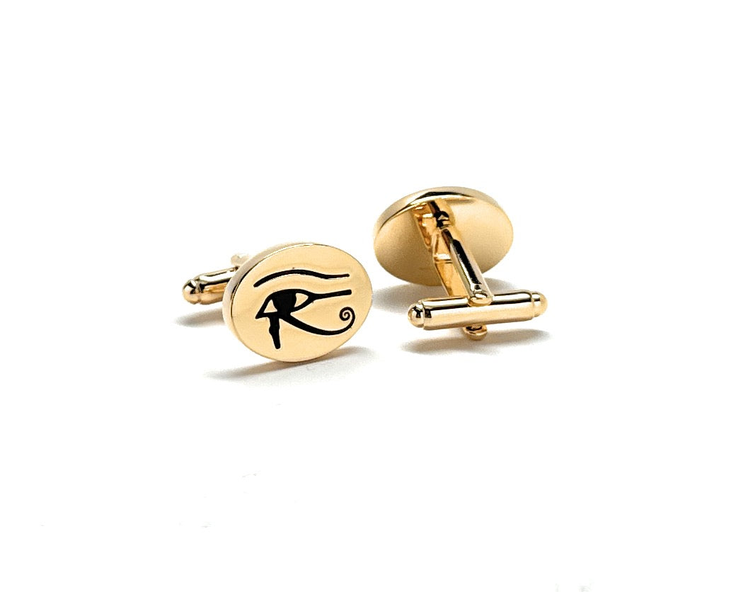 Gold cufflinks with an eye symbol on a white background