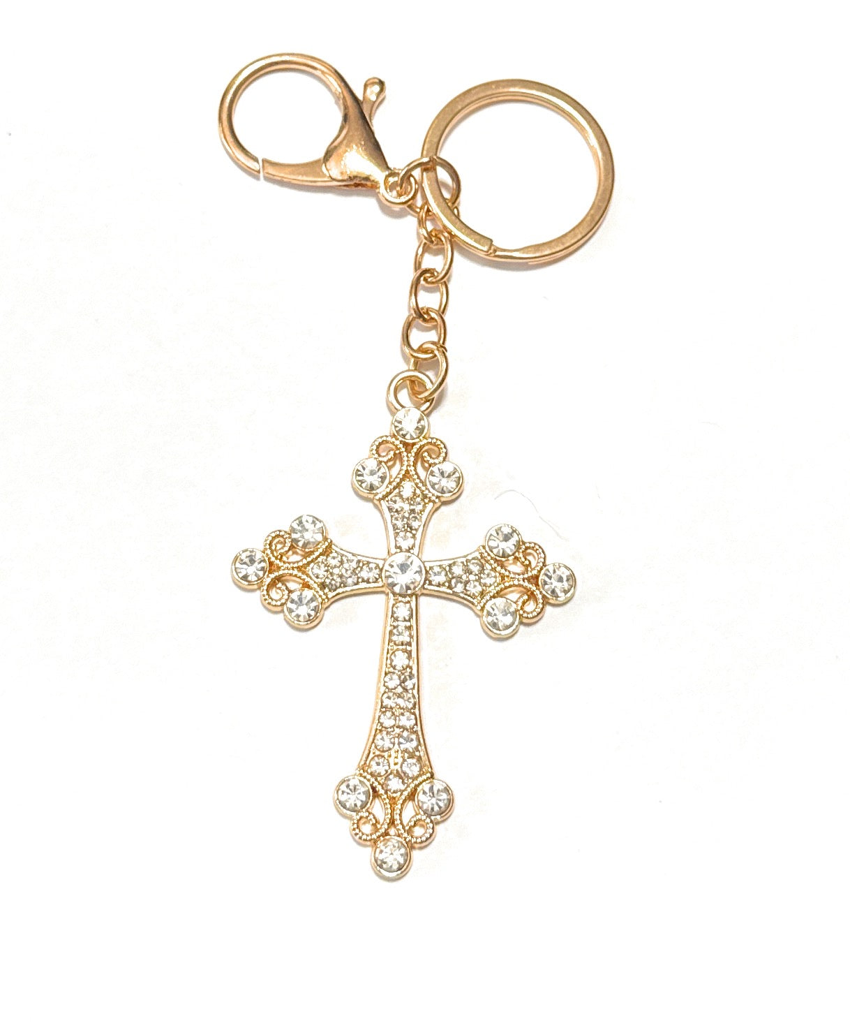 Gold cross keychain with clear stones on a white background