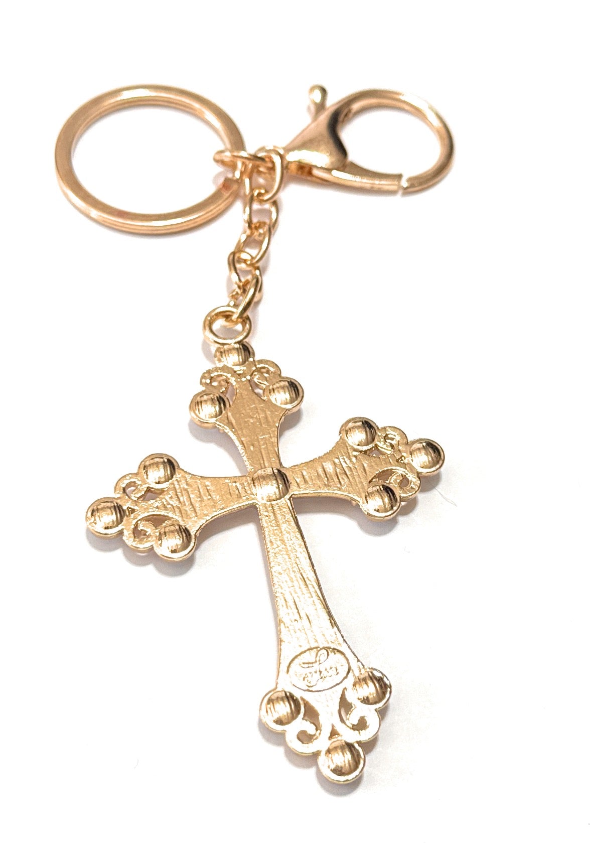 Gold cross keychain on a white background