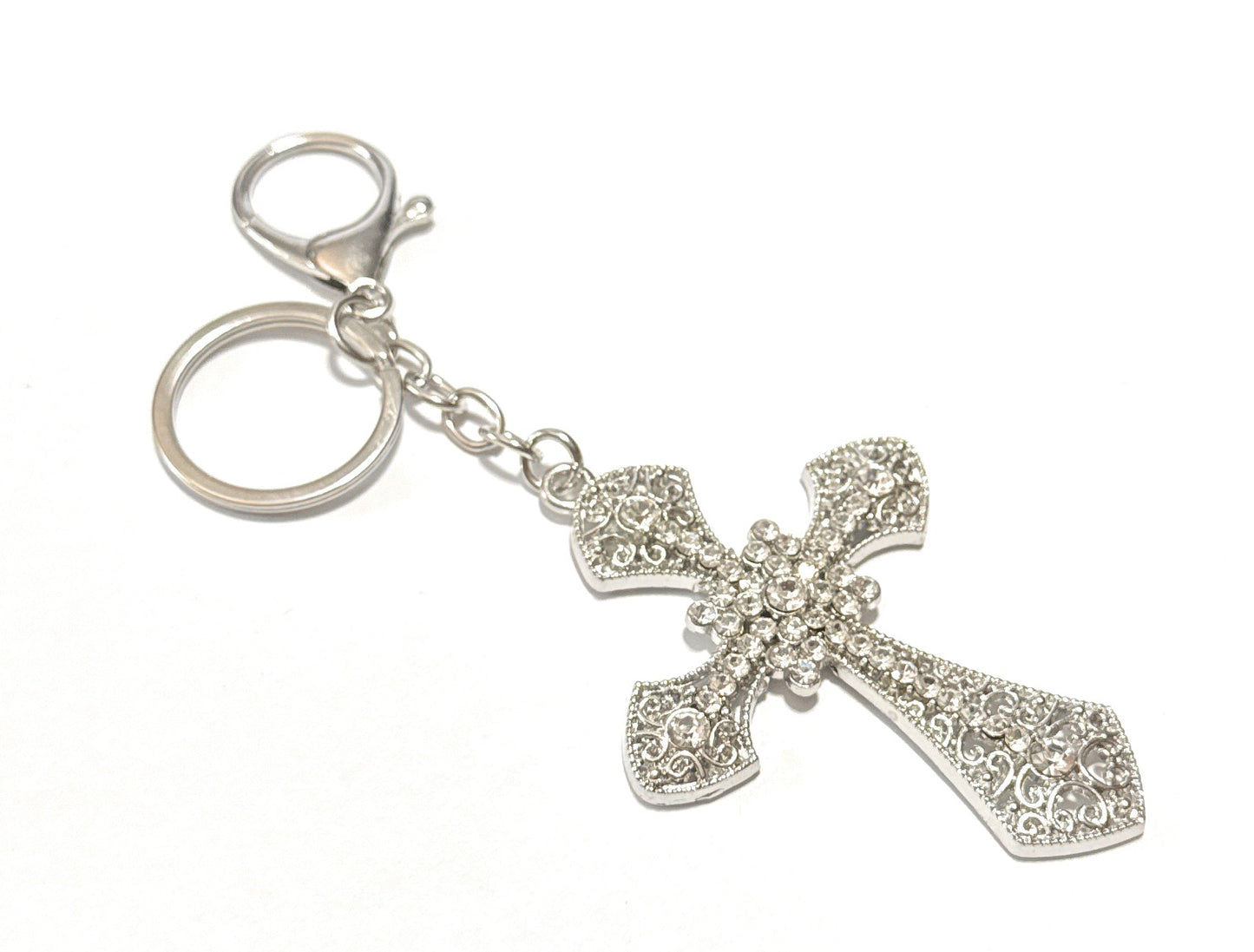 Silver cross-shaped keychain on a white background