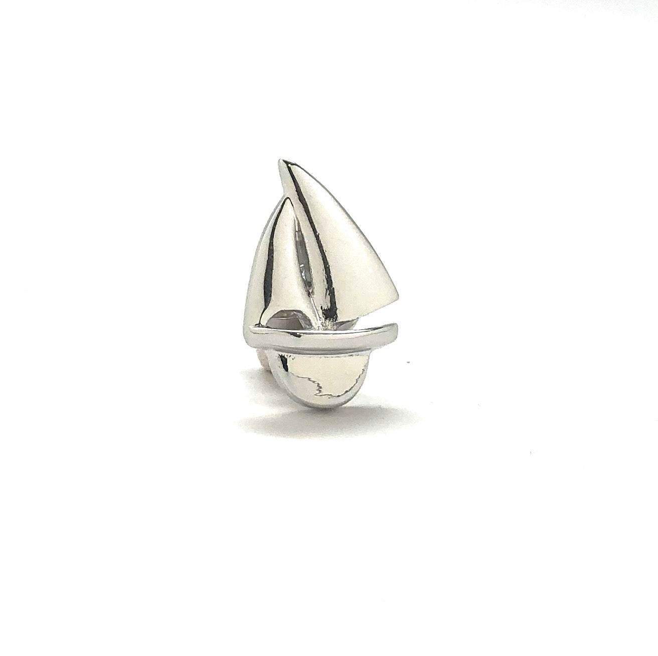 Silver sailboat charm on a white background