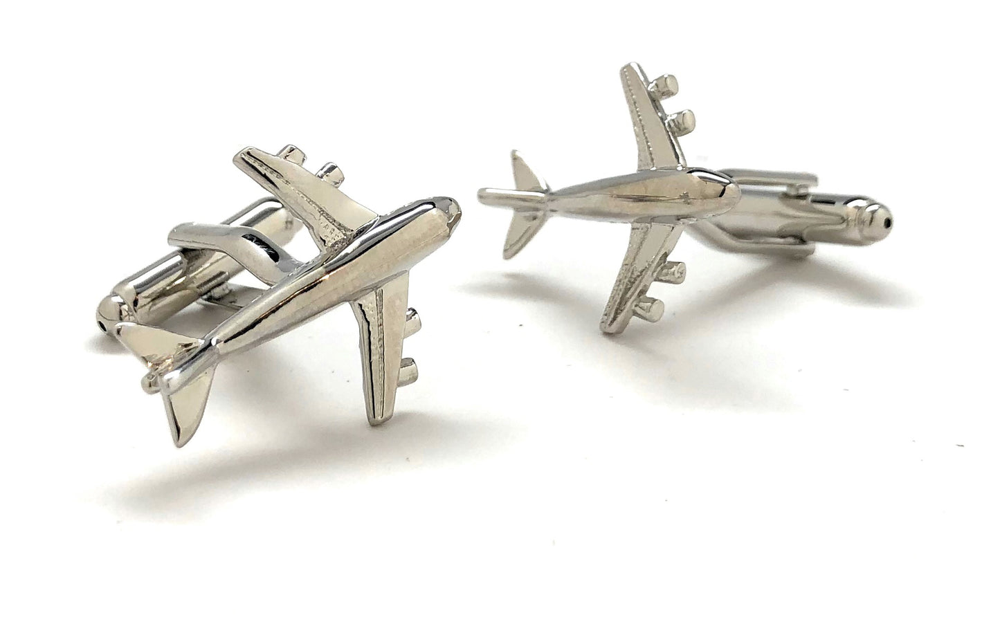 Silver airplane-shaped cufflinks on a white background