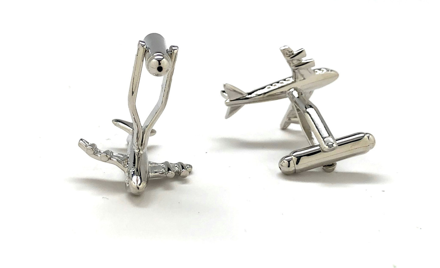 Silver airplane-shaped cufflinks on a white background