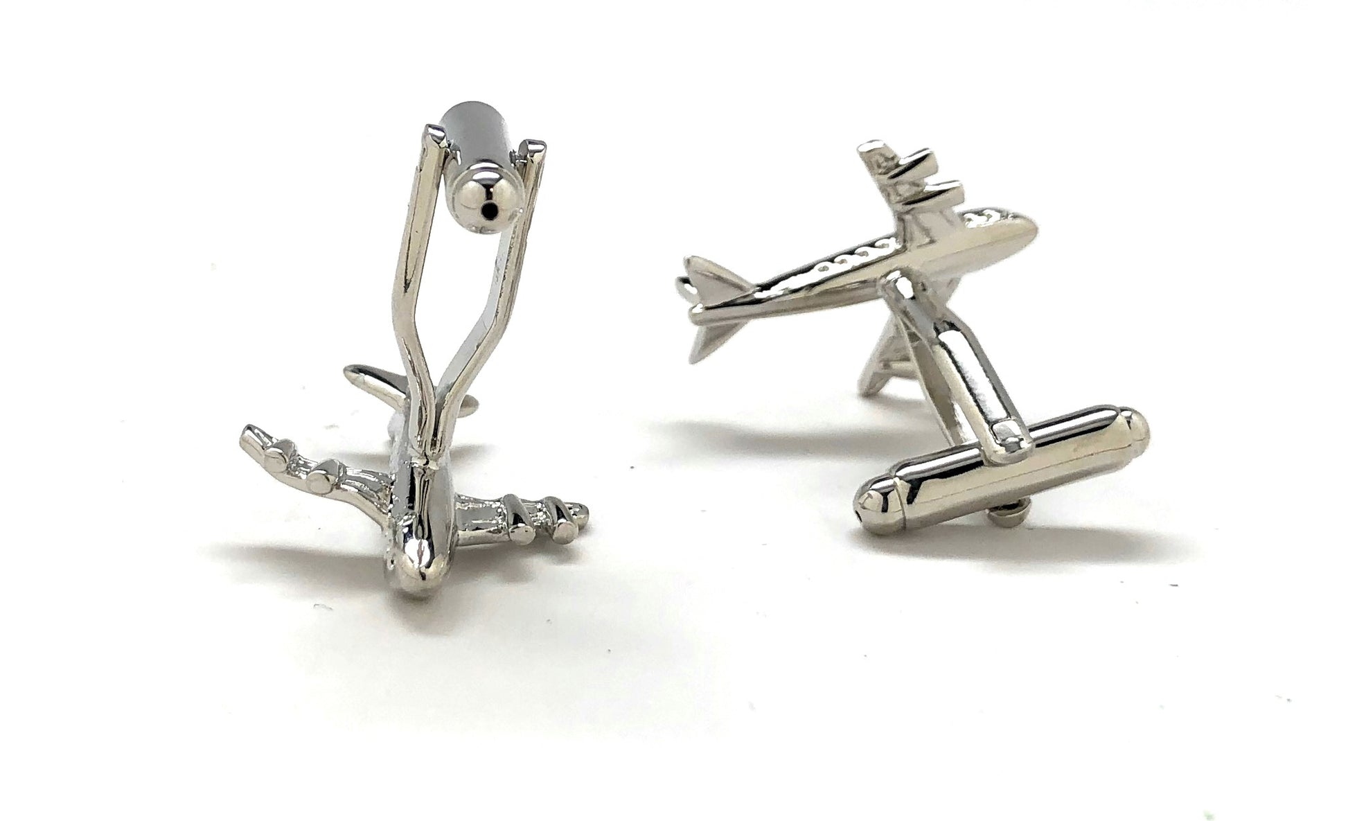 Silver airplane-shaped cufflinks on a white background