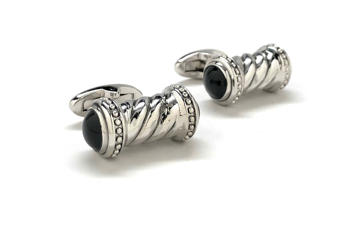 Silver cufflinks with black gemstones on a white background
