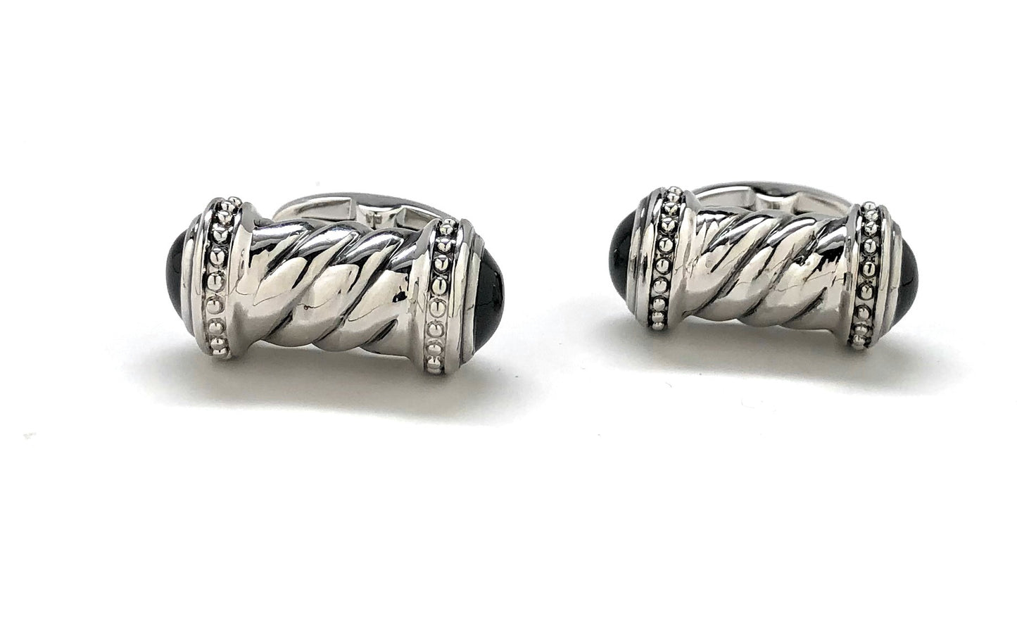 Pair of silver earrings with black centers on a white background