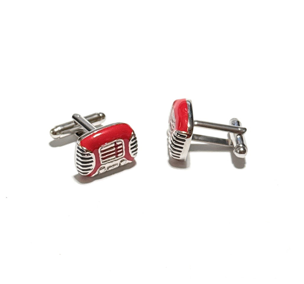 Red and silver cufflinks shaped like vintage radios on a white background
